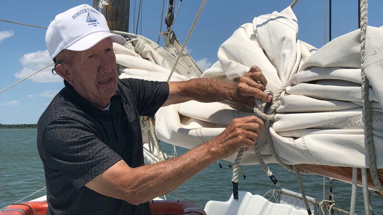 Captain Wade Murphy ties the sails on the Rebecca T. Ruark.