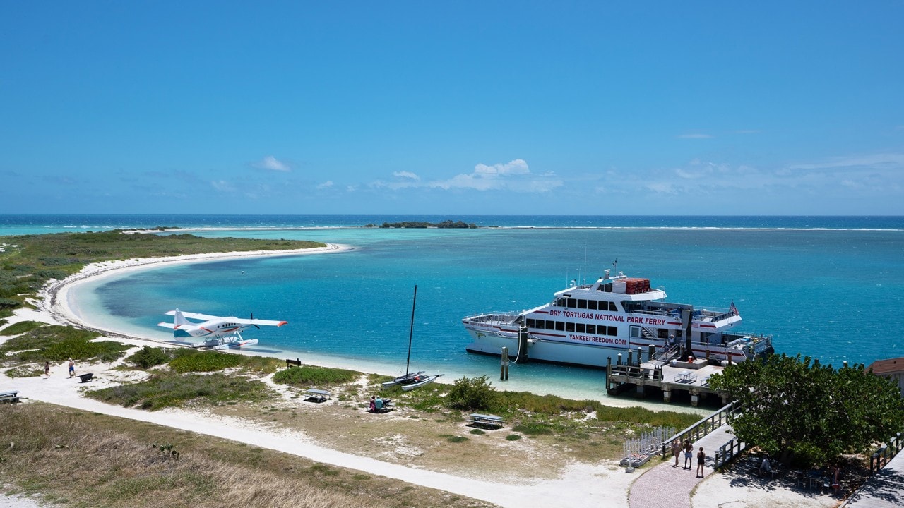 A seaplane and the Yankee Freedom III boat lie anchored off Dry Tortugas National Park.