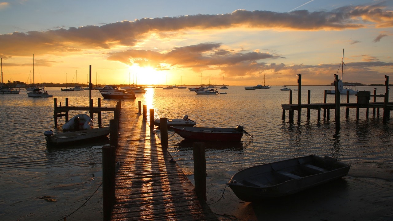 The sun rises on small boats tied up near Bay Drive South in Bradenton Beach.