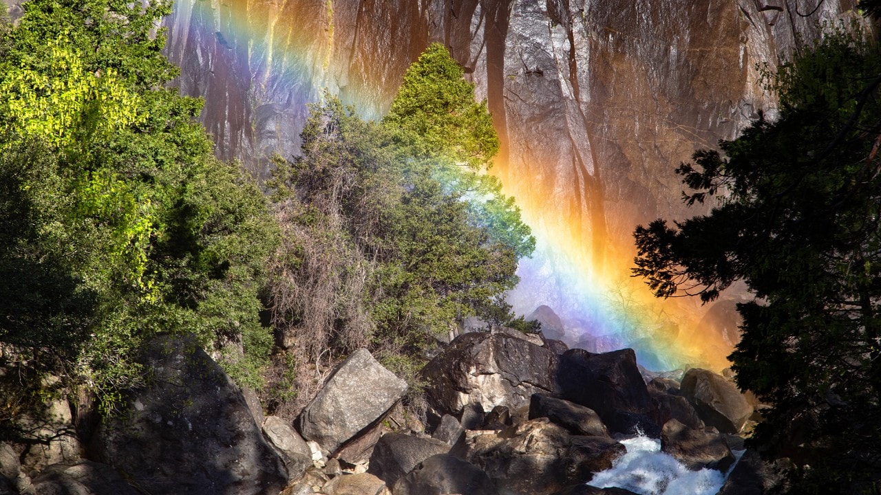 A rainbow appears in the mist of Lower Yosemite Falls. 