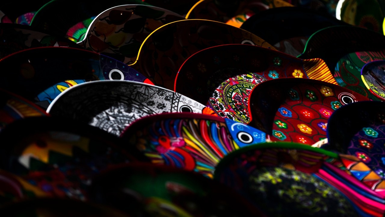 Decorated plates sit on a table at an open-air market at Chichén Itzá.