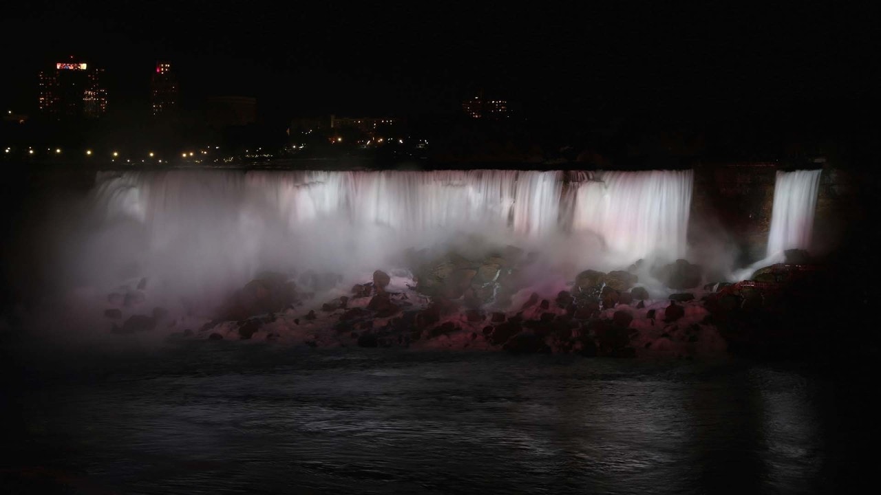 Niagara's waterfalls are lit up at night.
