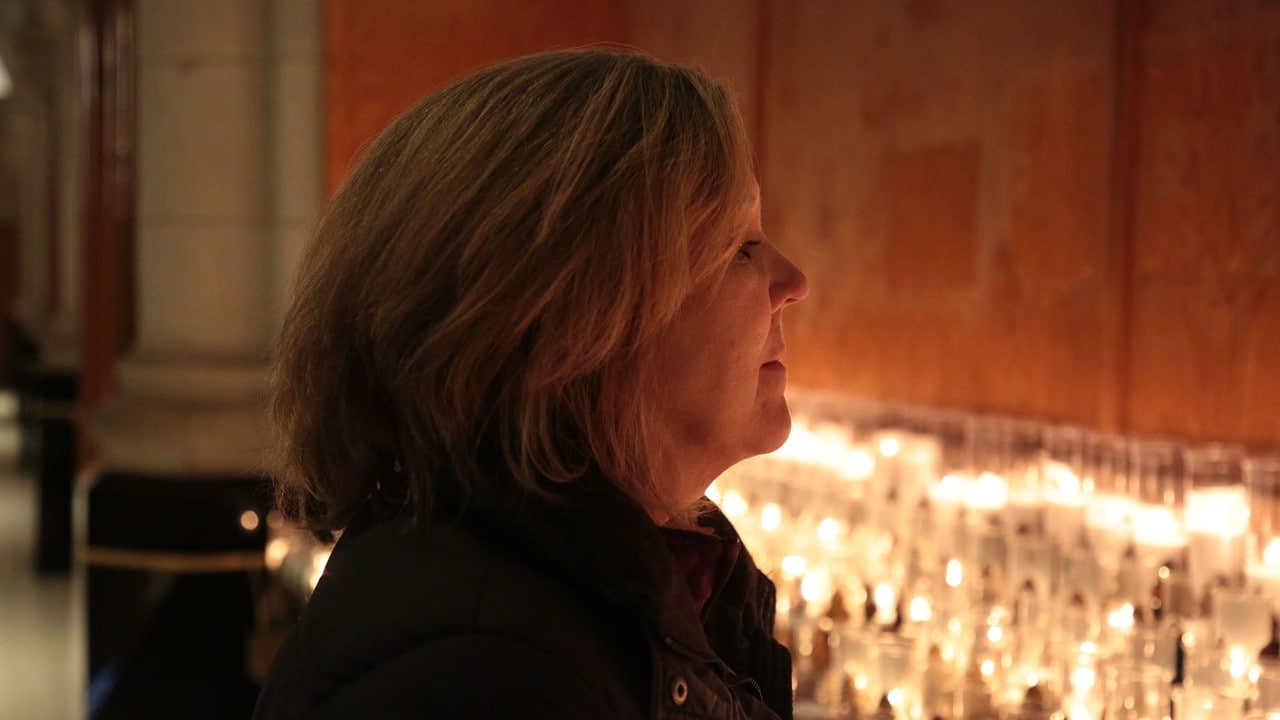 A visitor lights a candle.