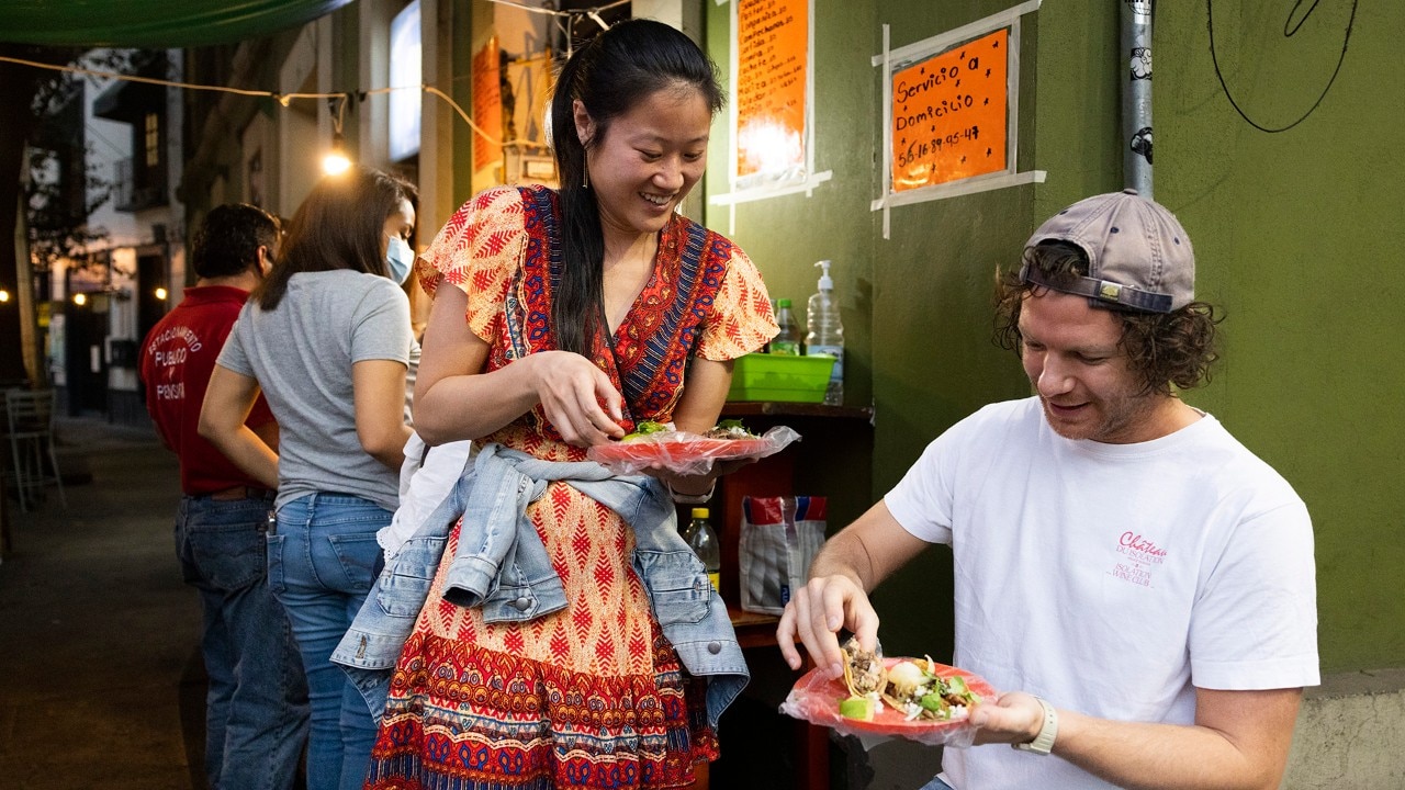 Zoe Berling (left) and Max Hutchison enjoy tacos while on a food tour with Eat Like a Local.