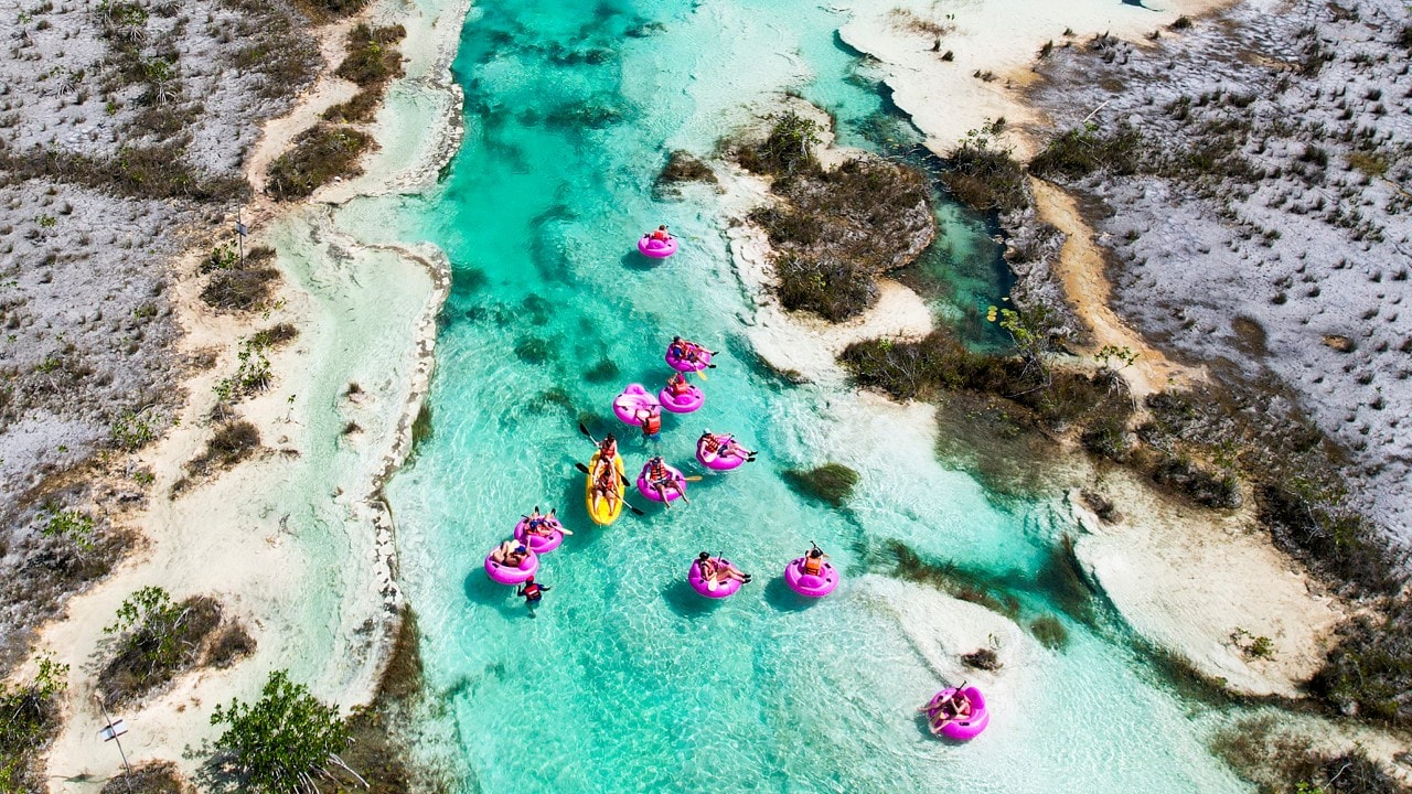 Pink inner tubes float down Los Rapidos at the Bacalar Lagoon.