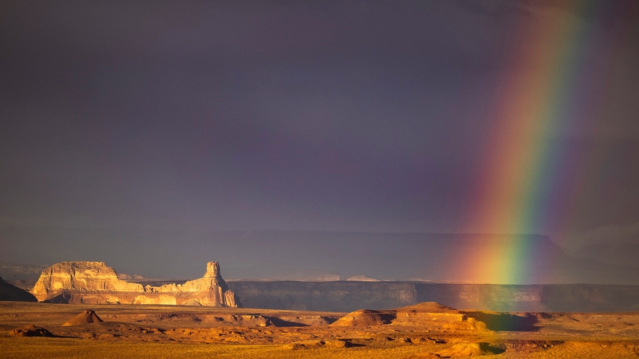 A rainbow appears in the desert after a rainstorm.