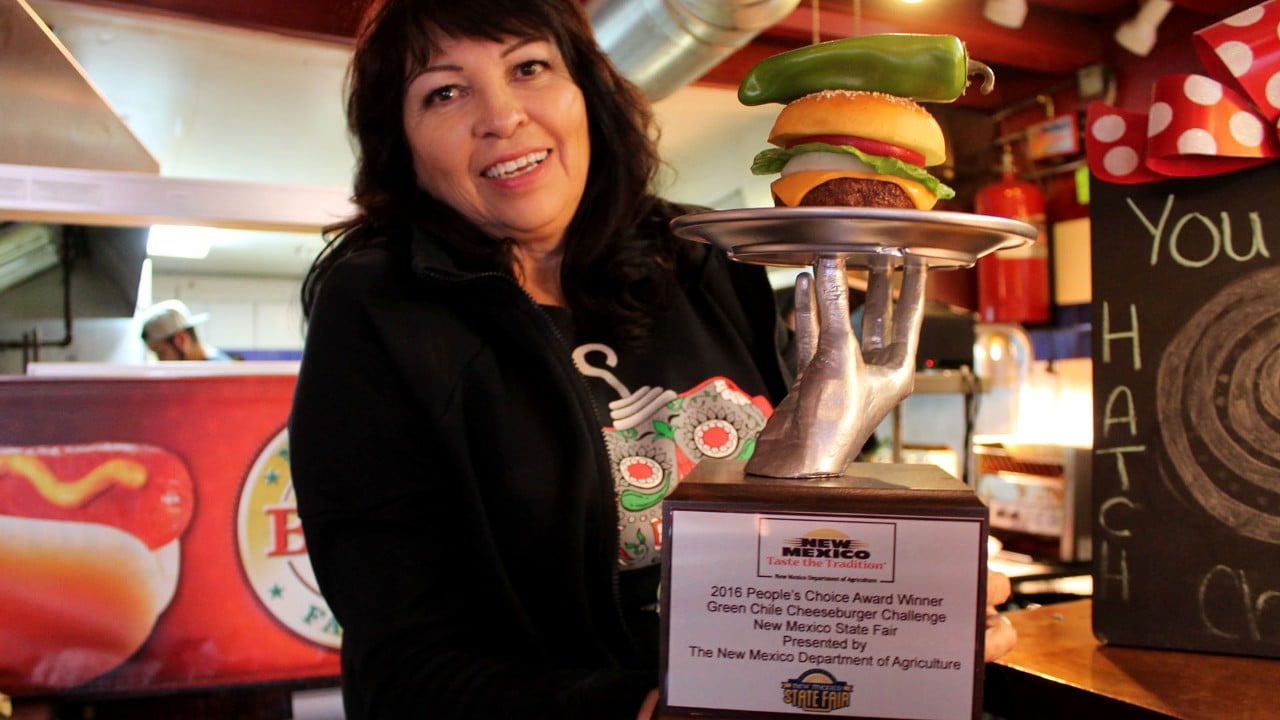 Josie Nunn shows off Sparky's green chile cheeseburger trophy.