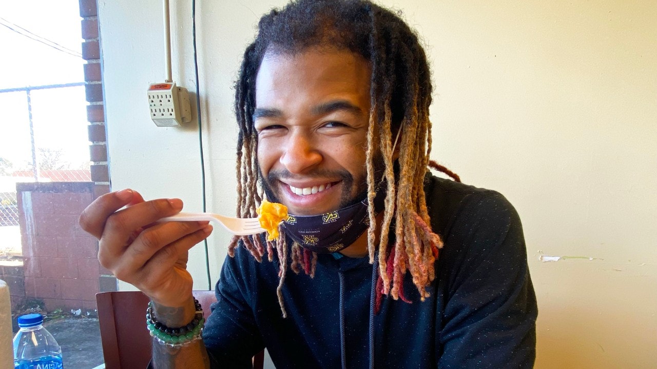 Rashaan digs into delicious mac 'n' cheese at Manna House Cafe.