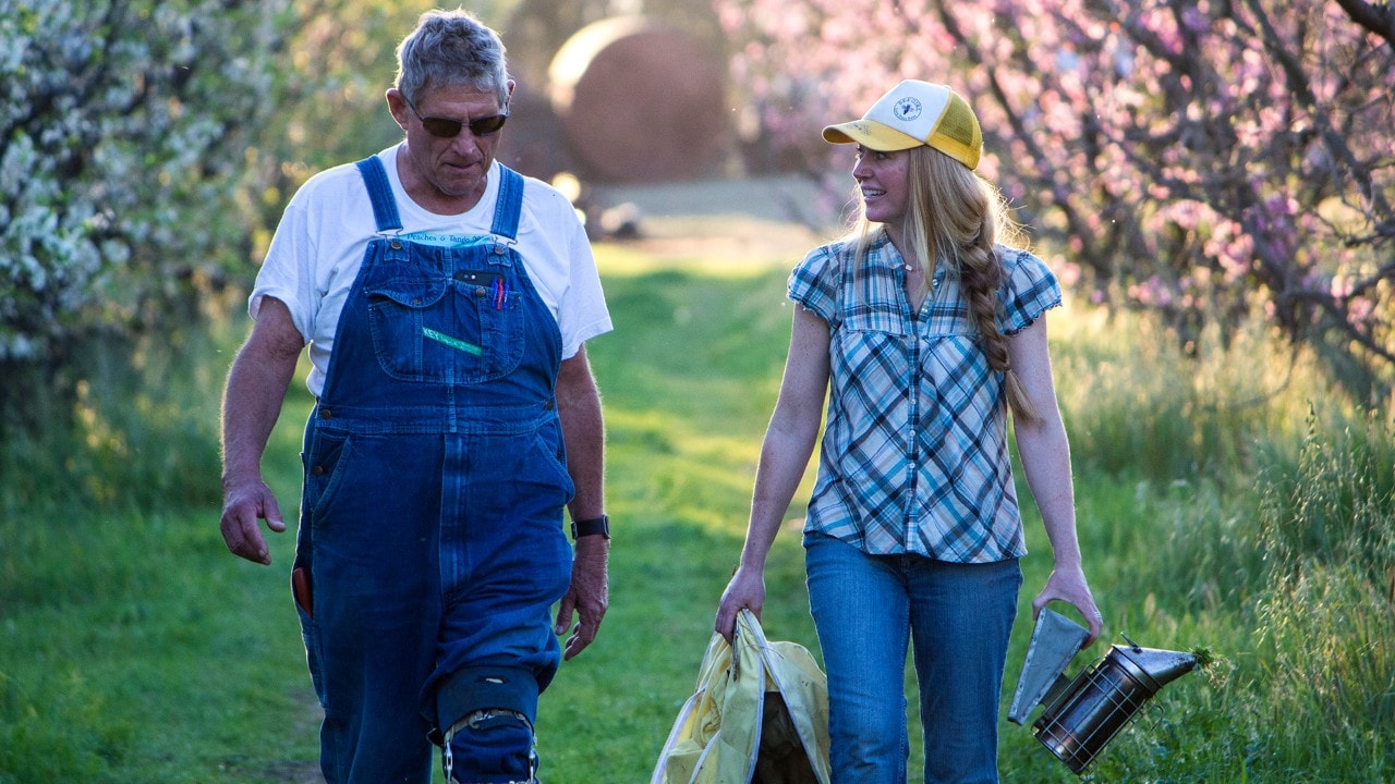 Farmer Al and Sarah share stories while strolling through the Frog Hollow orchards. Photo by Jay Zschunke