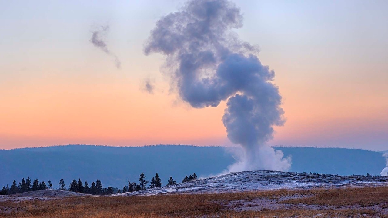 Old Faithful erupts during a sunset. Photo by Getty Images
