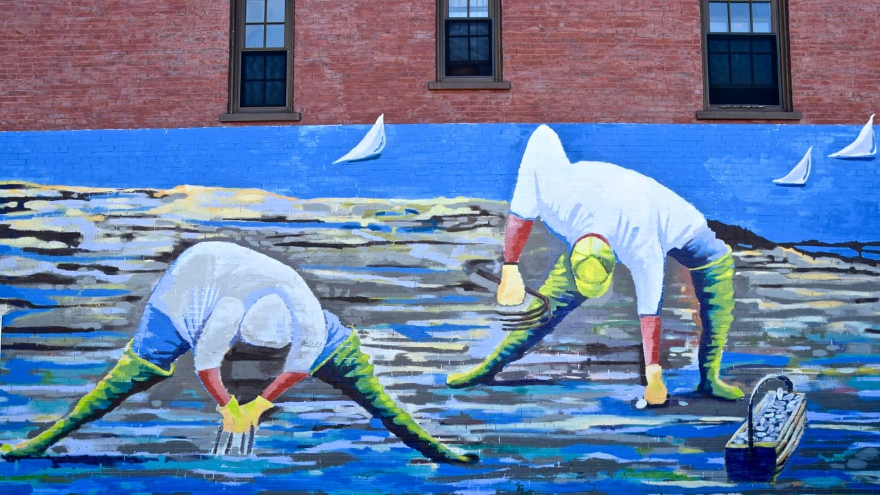 A mural depicting clam diggers decorates a wall in the East End neighborhood of Portland.