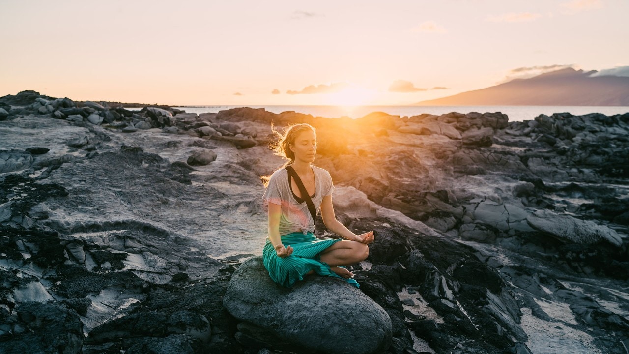 Maria Russo meditates on the volcanic rocks at Dragon's Teeth on Maui. Photo by Anthony Russo
