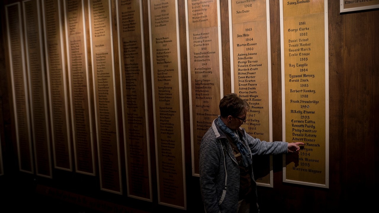 Heritage interpreter Paula Masson in front of the wall memorializing all of the fishermen who have lost their lives at sea in the Fisheries Museum in Lunenburg, N.S. on Tuesday, June 27, 2017.