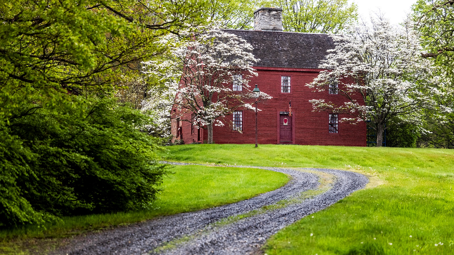 Trees bloom in front of a home outside Woodbury, Connecticut, along the Litchfield Hills Loop.