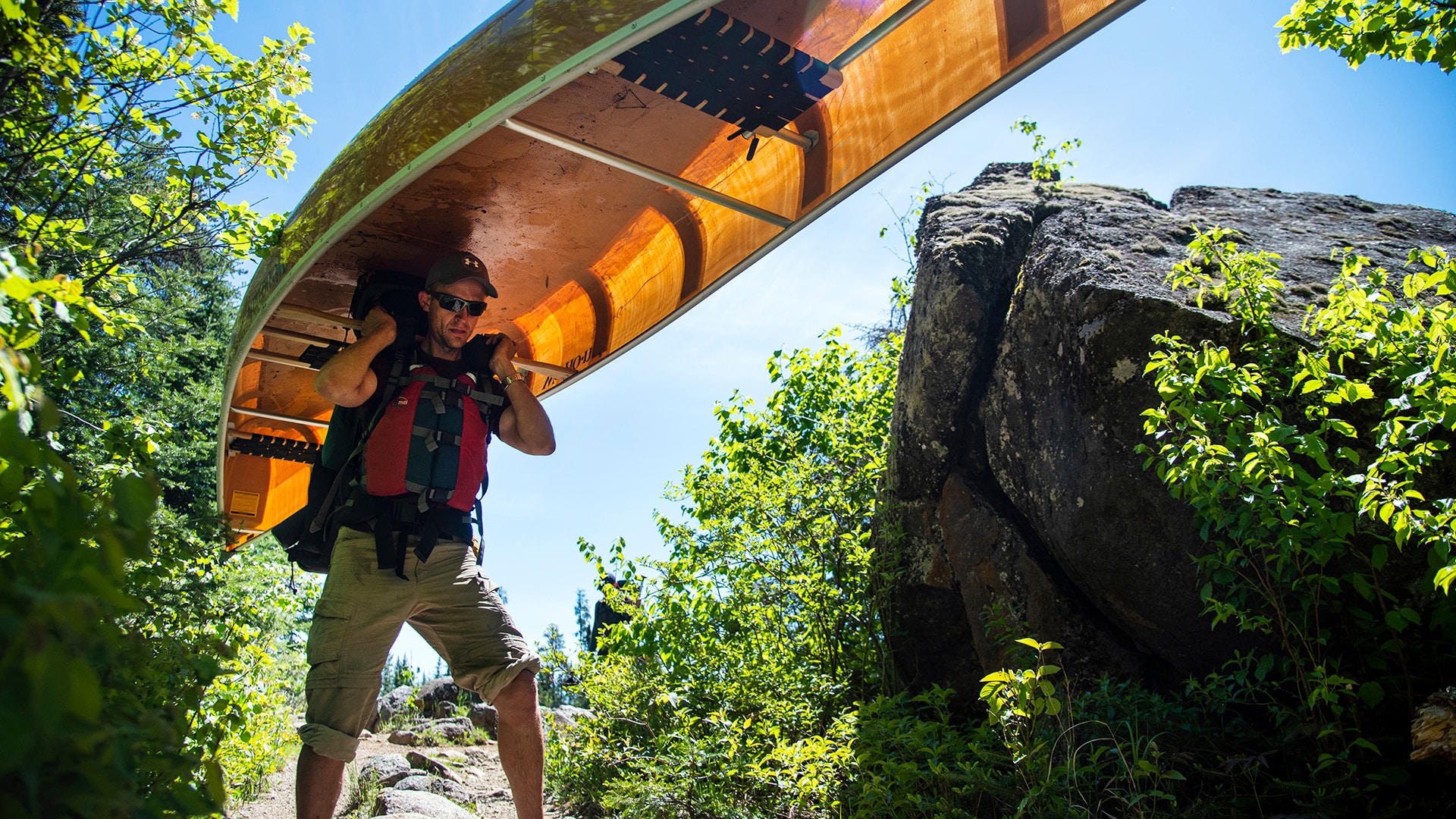 Peter portages the canoe from one lake to another, which is part of the BWCAW experience.
