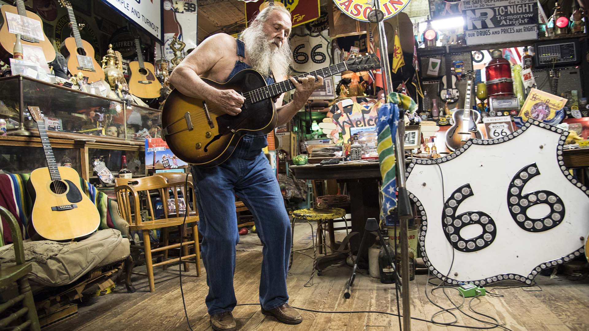 Harly Russell, the one-of-a-kind owner of the Sandhills Curiosity Shop in Erick, Oklahoma, plays guitar for visitors.