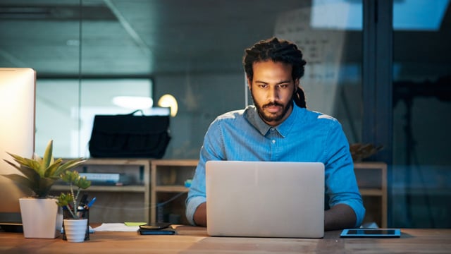 Cropped shot of a young designer working late on a laptop in an office