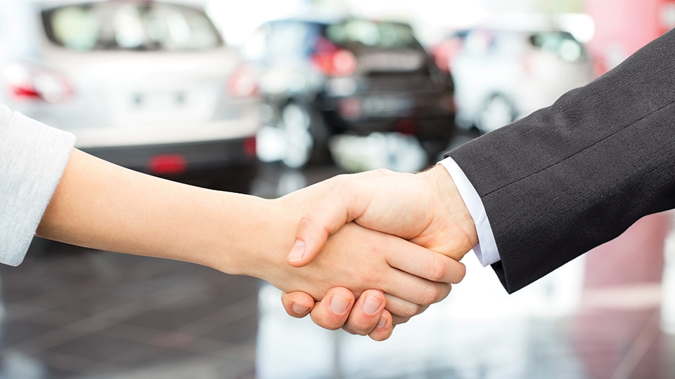 Cropped image of salesperson shaking hands with female customer. Horizontal shot.