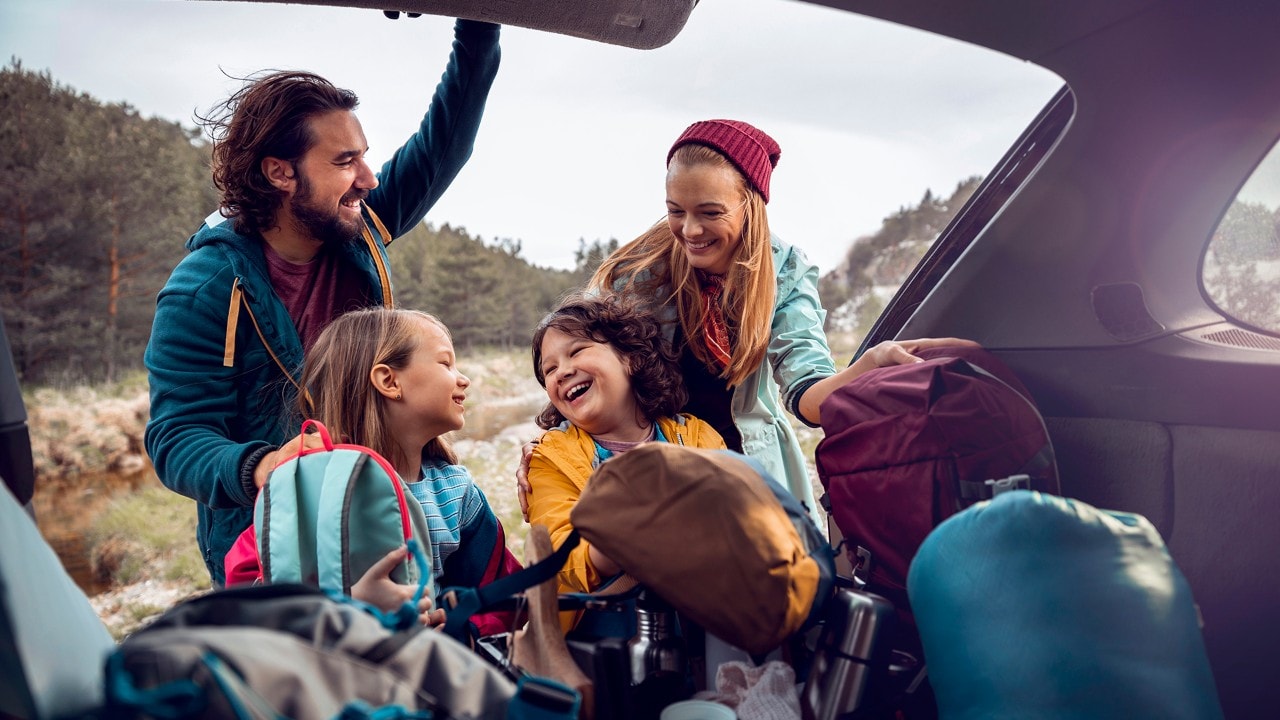 Close up of a young family getting the camping supplies out of the car