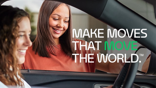 Woman Helping another woman who is in the drivers seat of a car. Text on the image reads " Make moves that move the world."