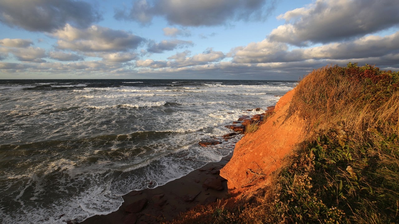 The Gulf of St. Lawrence crashes into the red-dirt cliffs on the north shore.