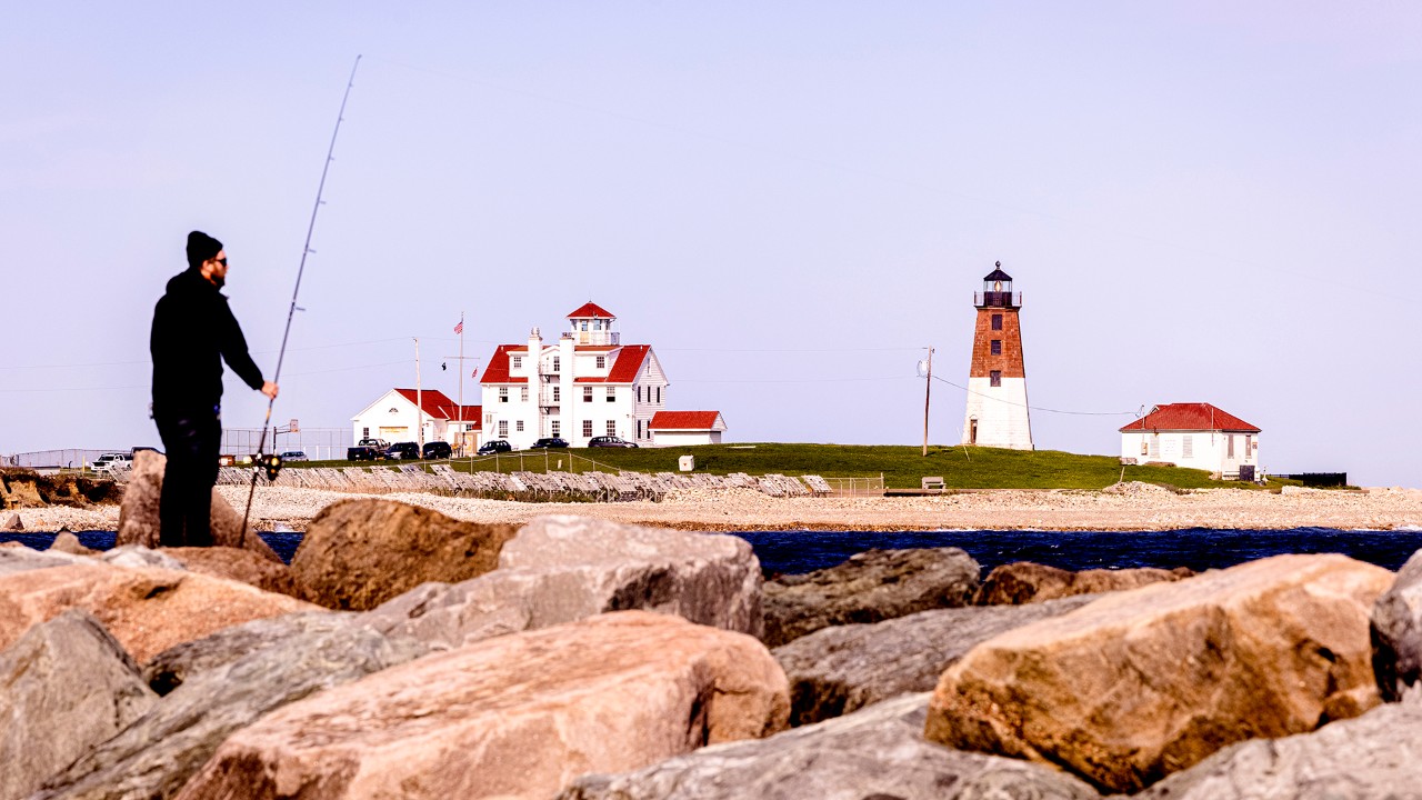 A fisherman looks out toward Point Judith Lighthouse in Narragansett, Rhode Island. 