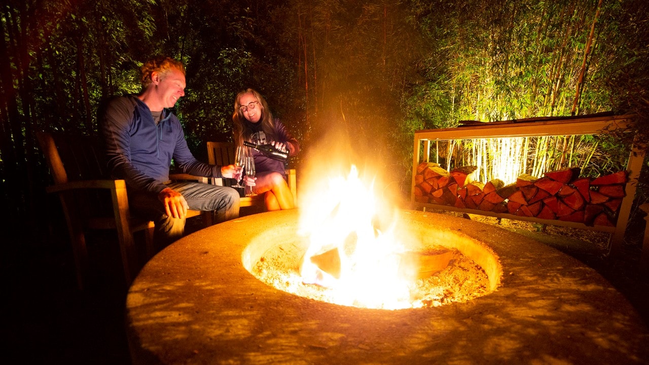 Brad and Tonya Clement enjoy champagne by firelight at their glamping accommodations at Manzanita, Oregon. Photo by Brad Clement