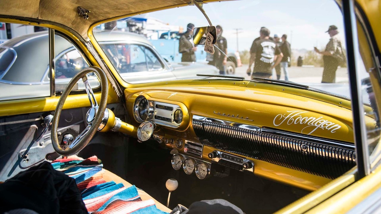 Classic hot rod enthusiasts take a break from driving old Route 66 in Ludlow, California.