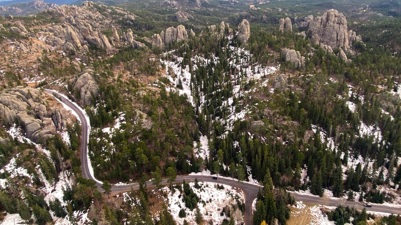 The Needles Highway snakes its way through granite spires and Ponderosa forest.