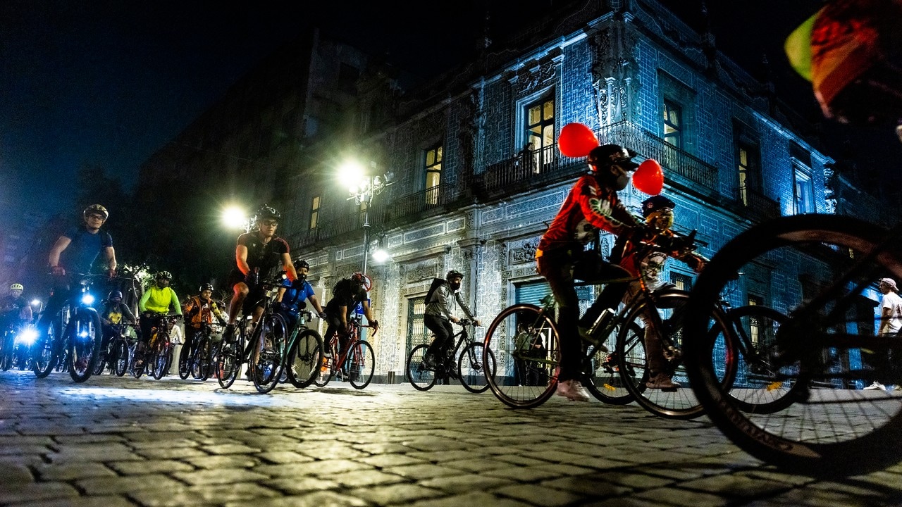 Cyclists ride past the Casa de los Azulejos, the "House of Tiles."