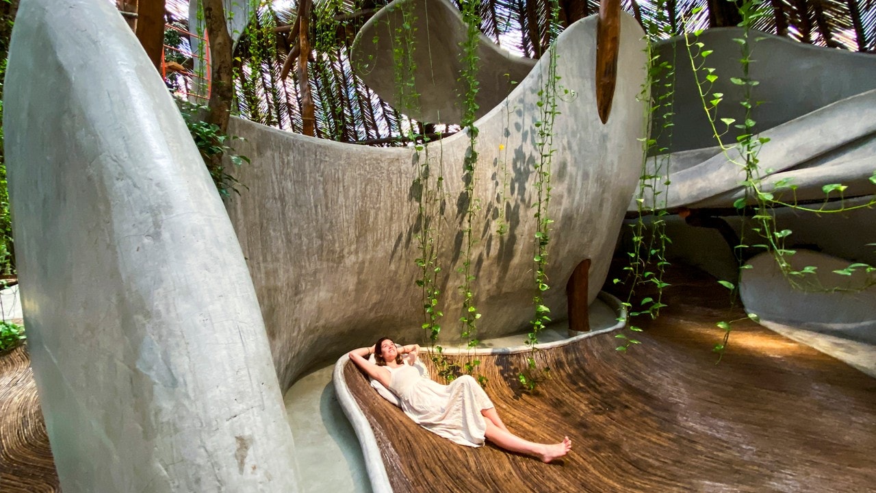 AZULIK Uh May fascinates visitors with sculpted concrete, hanging plants and floors made of lacquered branches.