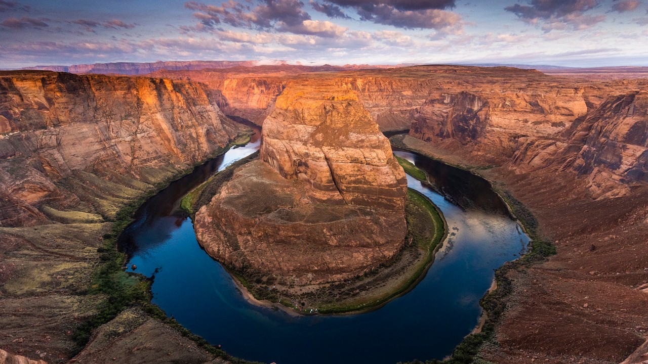 The sunrise illuminates the Colorado River as it flows around Horseshoe Bend.