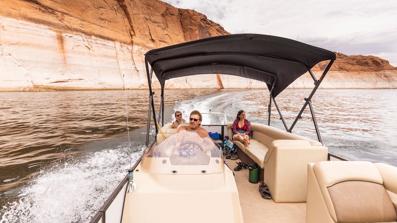 Mike guides a rental boat between the walls of Navajo Canyon on Lake Powell.