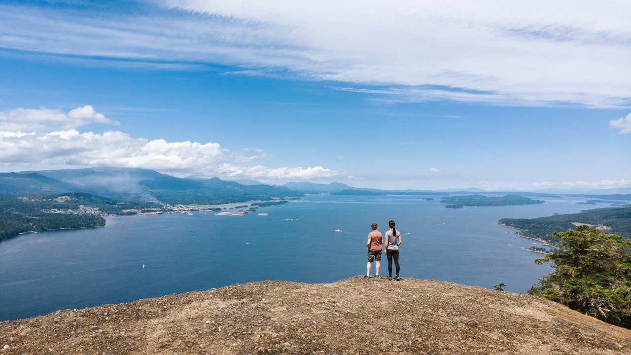 The author (right) and her mom look toward Maple Bay from atop Mount Erskine in British Columbia.