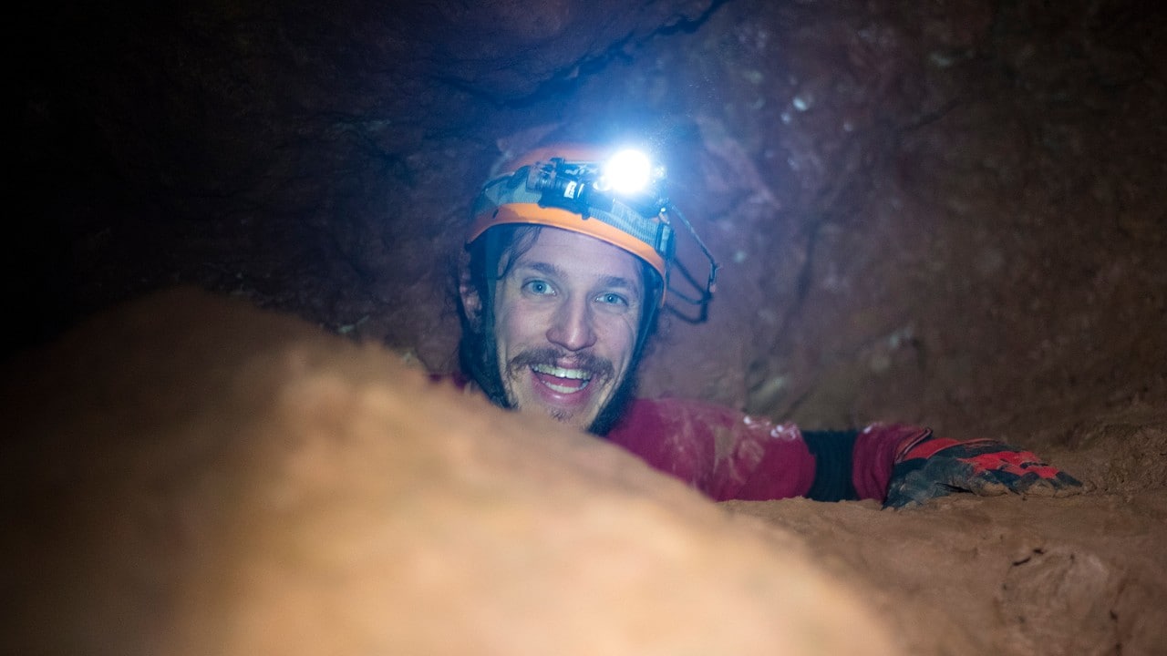 Kevin Chase smiles after making it through a recently found passageway in Rushmore Cave. 