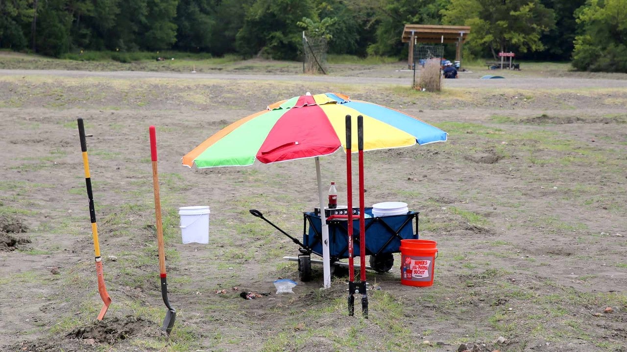 A diamond searcher's camp includes shovels, a post-hole digger and an umbrella.