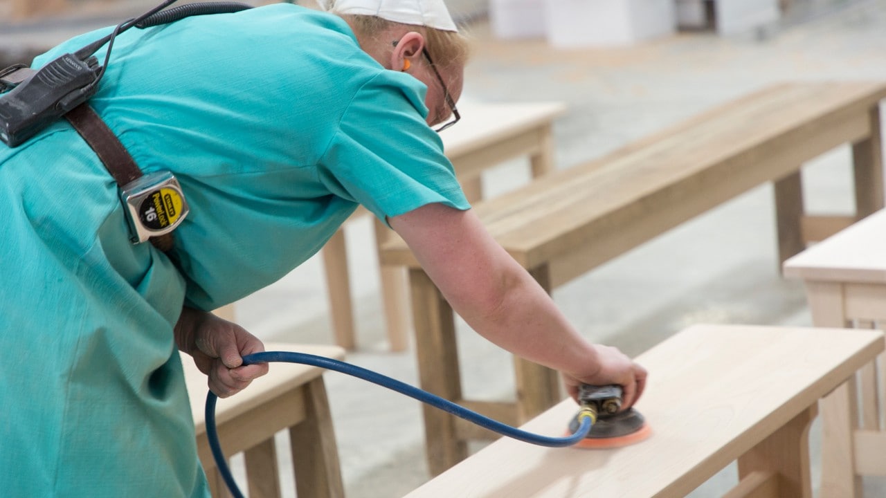 Sanding a bench at West Point Woodworking