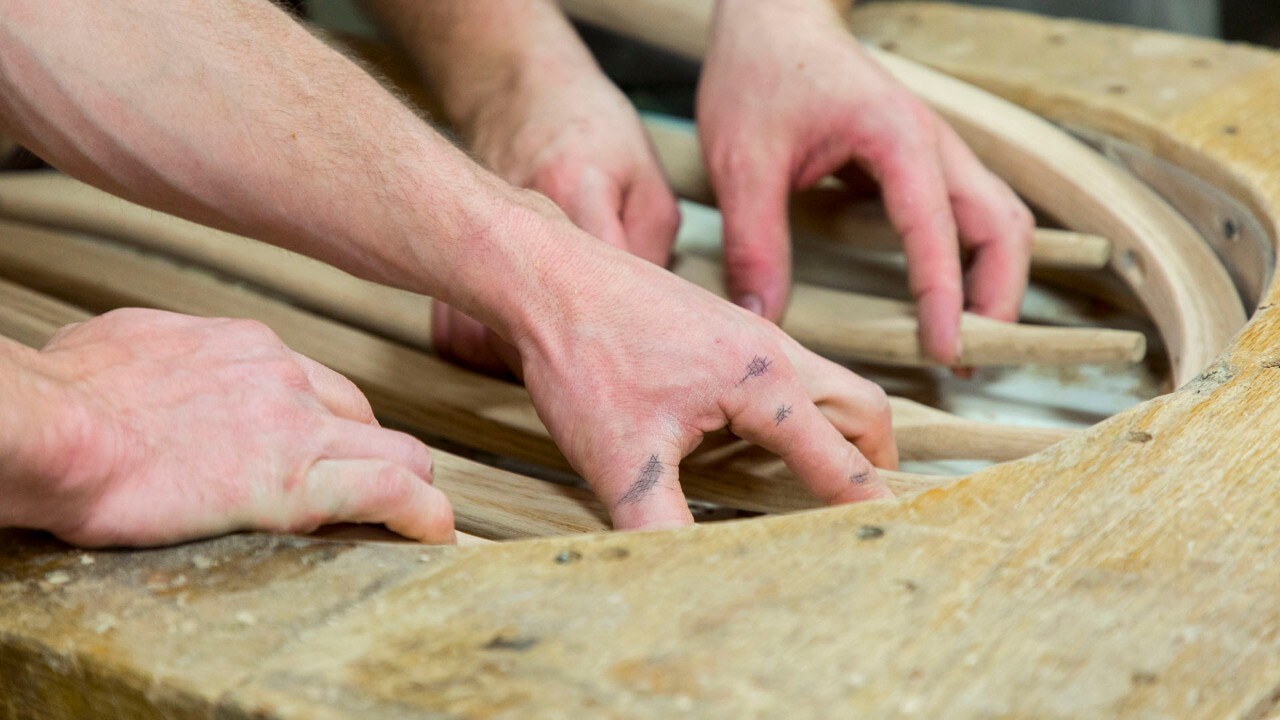 Workers assemble a chair by hand at F&N Woodworking in LaGrange, Indiana.