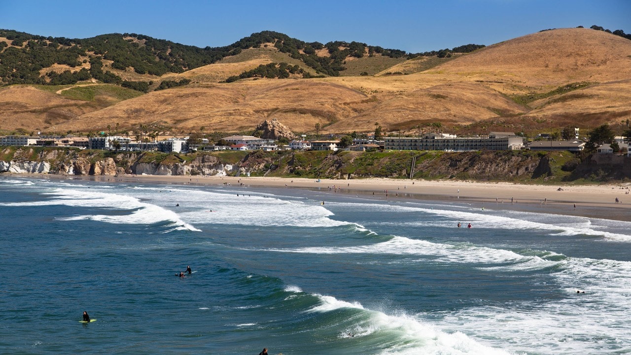 Surfers ride the waves at Pismo Beach, California.