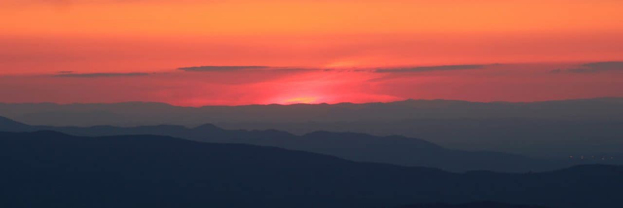 The sun slips behind silhouettes of the Appalachian Mountains.