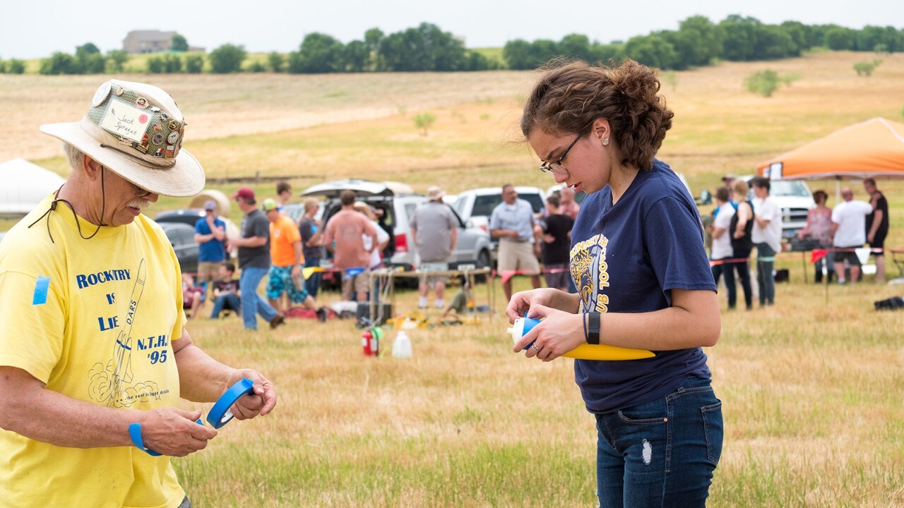 Jack has a passion for helping kids discover rocketry. Here, he helps Alex prep her model for launch. 