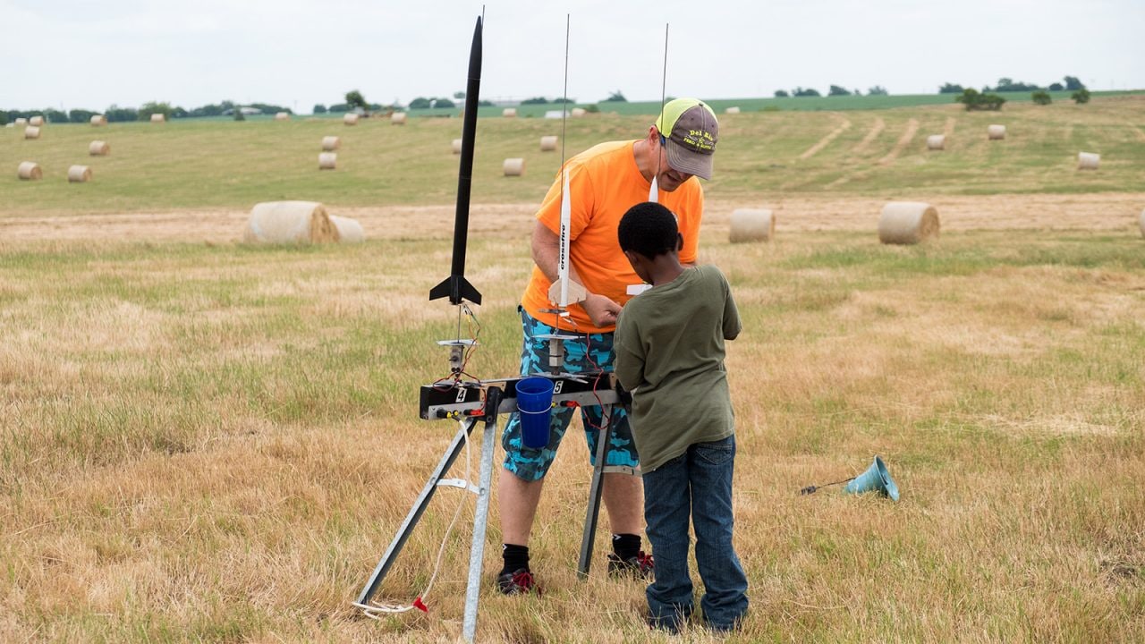 A DARS member assists a local Cub Scout with his small model rocket before launch. 