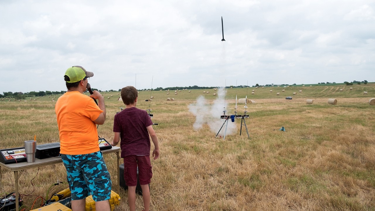 It can fly! A young rocketeer watches his successful launch from the control panel. 