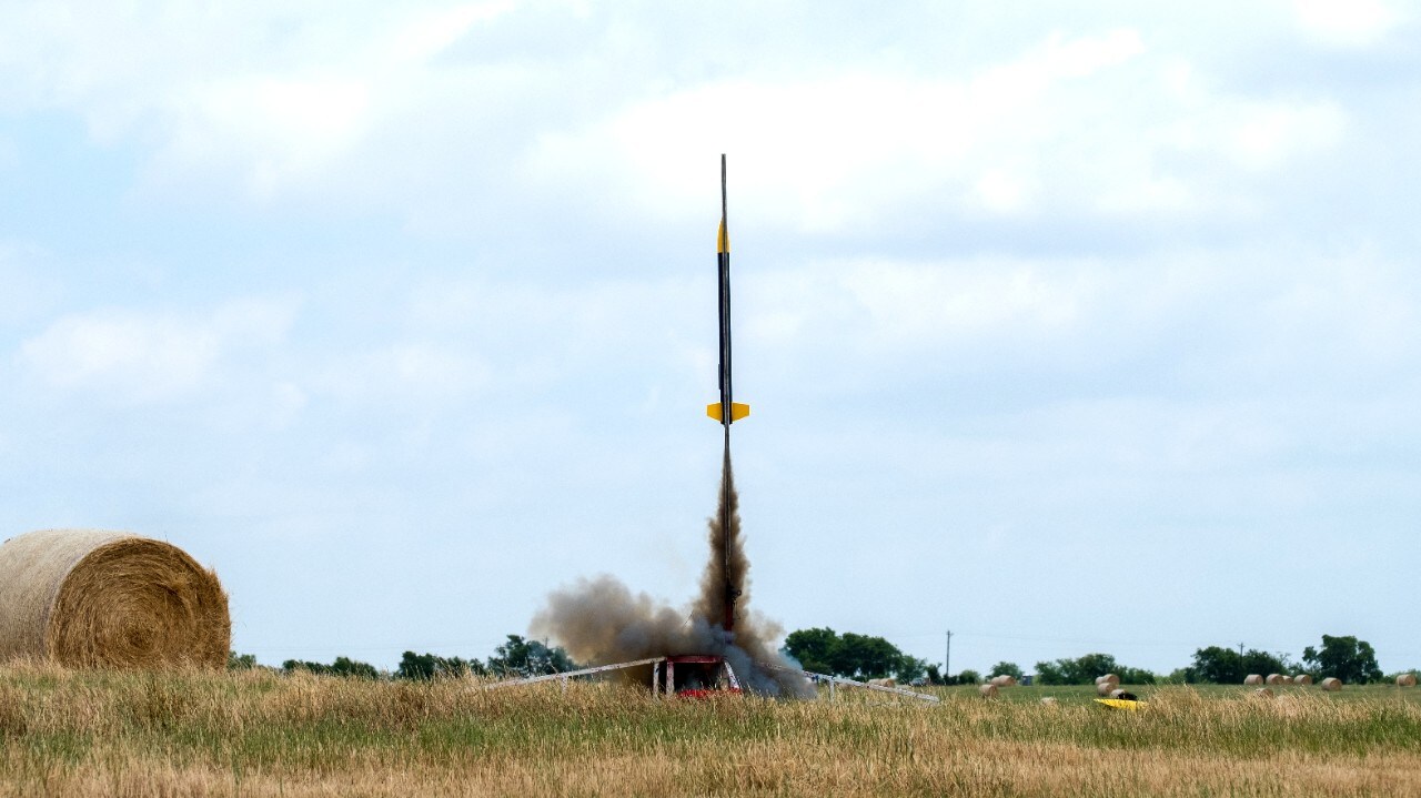 Alex’s model rocket ignites and takes off from the launch pad. 