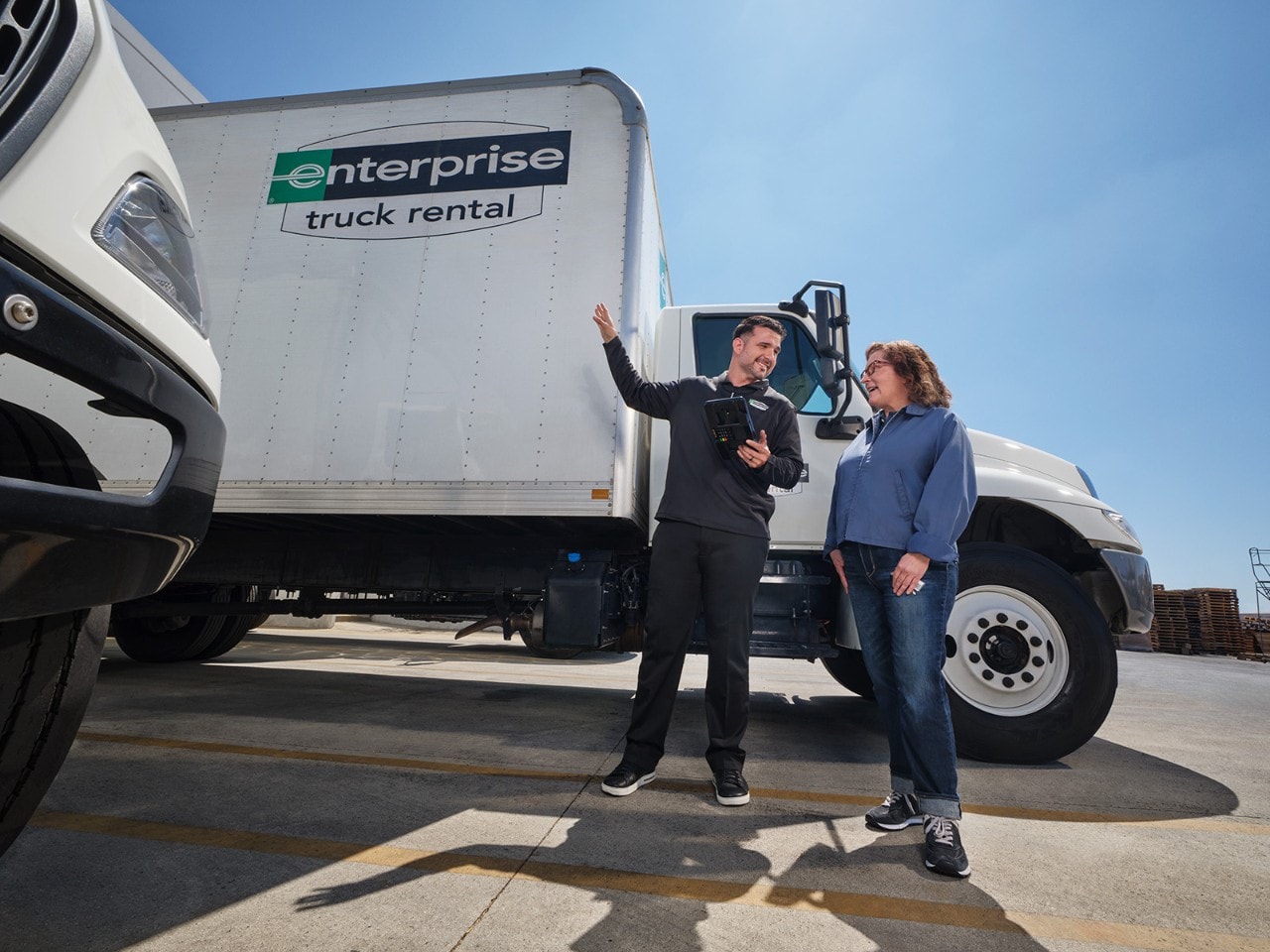 Man showing a woman a box truck