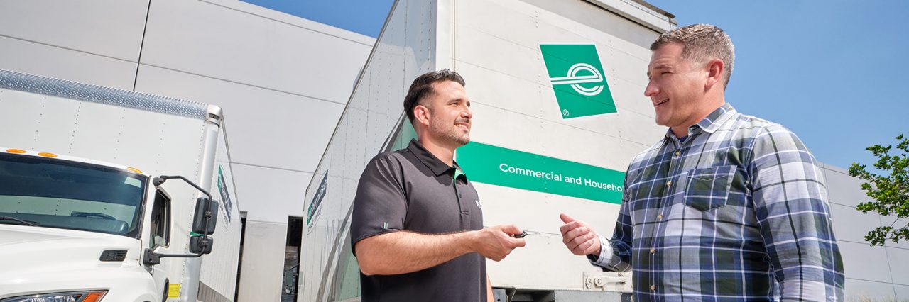 Hombre entregando las llaves al camión de caja al cliente. 